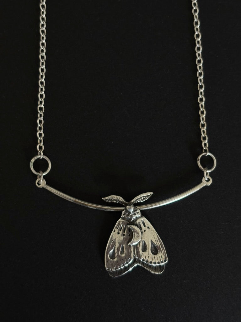 Silver moth pendant on black background. Handcrafted silver moth pendant with detailed wings, inspired by nocturnal nature and made in Ireland by Irish jewellery designer