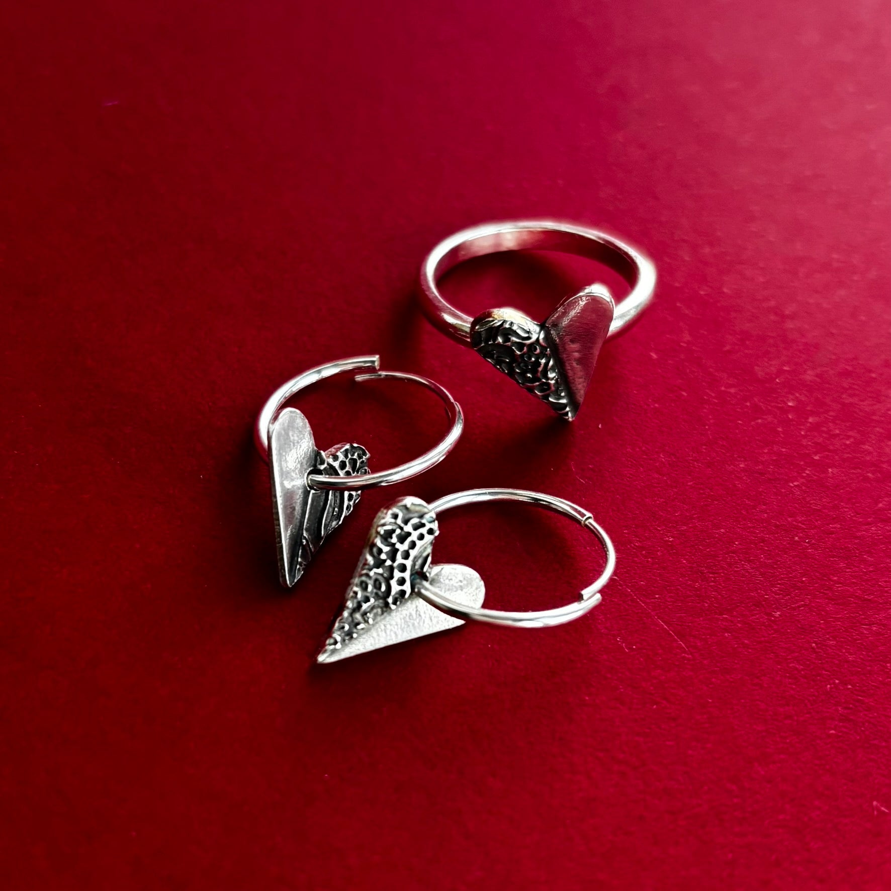 Handcrafted silver earrings featuring delicate heart-shaped charms, designed with a minimalist shine and perfect for everyday wear or special occasions, sustainable jewellery made with recycled silver.