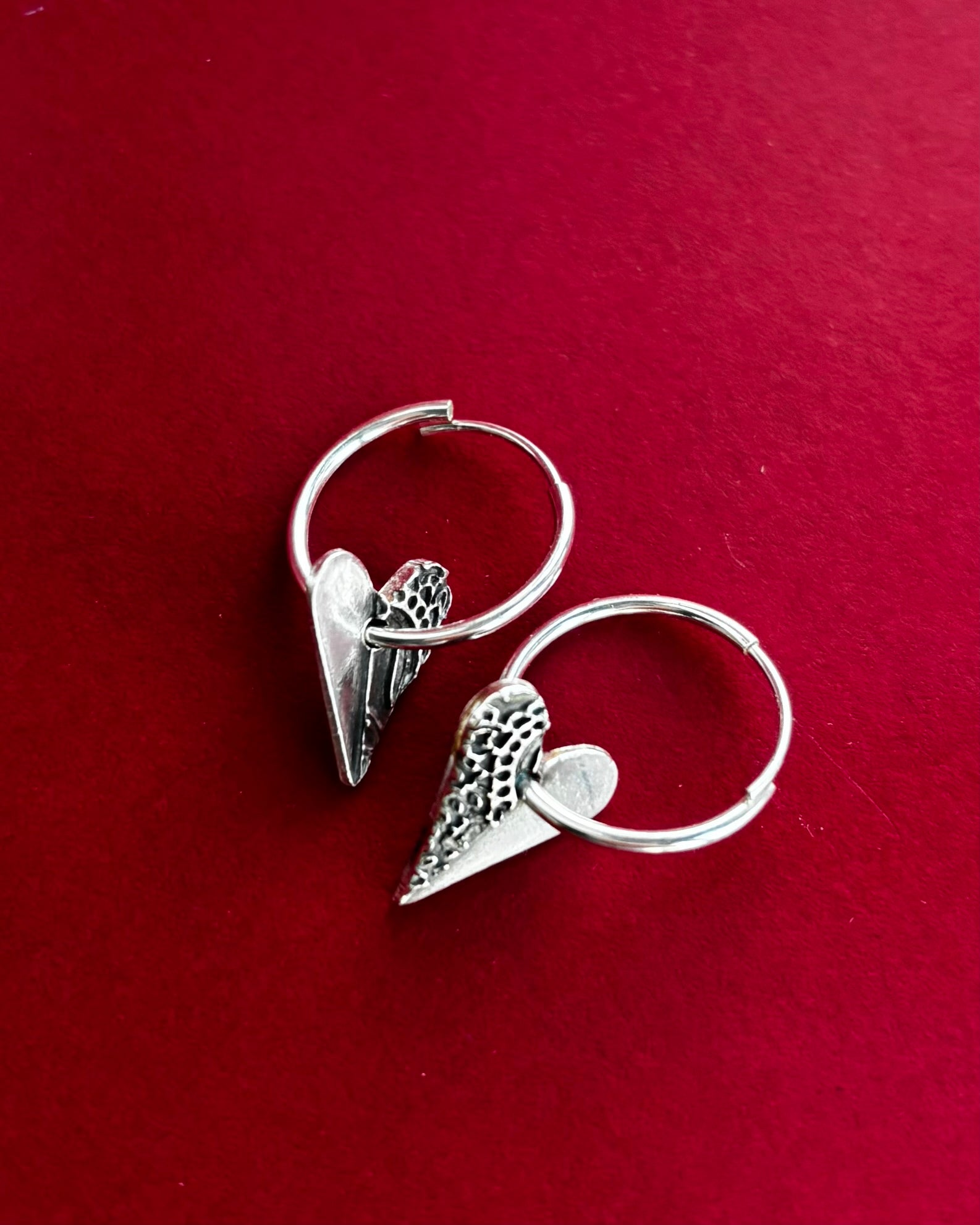 Handcrafted silver earrings featuring delicate heart-shaped charms, designed with a minimalist shine and perfect for everyday wear or special occasions, sustainable jewellery made with recycled silver.